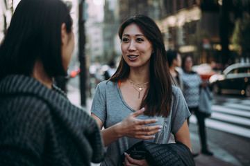 Two japanese women around in Tokyo during daytime. Making shopping and having fun