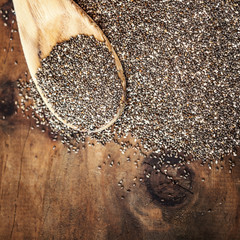 Chia seeds in wooden spoon on wood background. Bowl of Chia seeds. Top view.  Copy space..