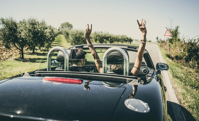 Couple driving on a convertible car and having fun