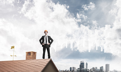 Engineer man standing on roof and looking away. Mixed media