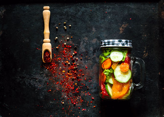 Fototapeta na wymiar homemade salad of healthy vegetables in a glass jar on vintage rusty metal background, organic food concept, diet, detox, clean food or vegetarian concept, copy space, closeup