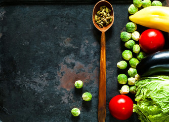  wooden spoon with spices and fresh vegetables for healthy cooking on background of old rusty metals, top view,copy space, closeup. Diet, pure food or the concept of vegetarian food.