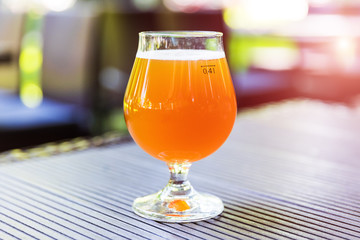 Glass of light beer on the table outdoors