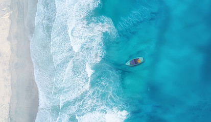 Wave and boat on the beach as a background. Beautiful natural background at the summer time from air © biletskiyevgeniy