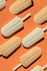 Varying  popsicles on an orange background. Flat lay of ice creams  in pop-art style. Vertical ...