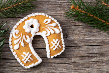 Christmas gingerbread cookie and spruce branches on a wooden background
