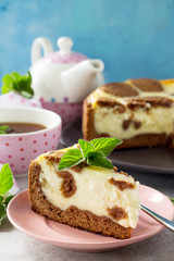Cheesecake and mint tea cup. Chocolate New York cheesecake and mint tea cup on concrete background.