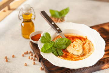 Fresh classic hummus with basil in the bowl