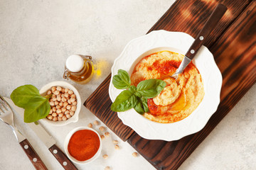 Fresh classic hummus with basil in the bowl top view