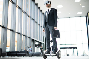 Modern businessman in suit wearing vr goggles and moving on hoverboaard along corridor or lobby