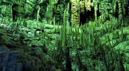 Cave dark interior with light, stalactites and stalagmites
