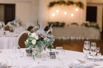 Wedding flowers. Art decoration of a table at a wedding and number of a table