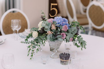 Wedding flowers. Art decoration of a table at a wedding and number of a table