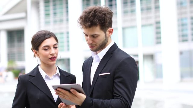 Couple of business people using a tablet outdoor