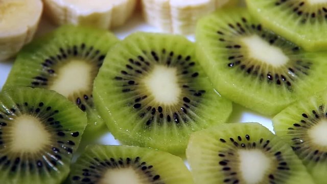 Fruit dessert of kiwi and bananas on a plate close-up with shallow depth of field