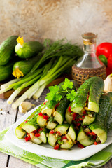 Korean traditional food Kimchi (Cucumber). Marinated cucumbers with vegetable filling (sweet pepper, garlic, onion, greens, tomato paste) on the kitchen wooden table.