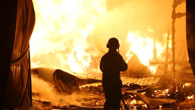 One Firefighter In Front Of A Burning Building