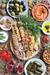 Middle eastern, arabic or mediterranean dinner table with grilled lamb kebab, chicken skewers  with...