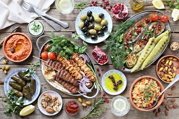 Middle eastern, arabic or mediterranean dinner table with grilled lamb kebab, chicken skewers  with...