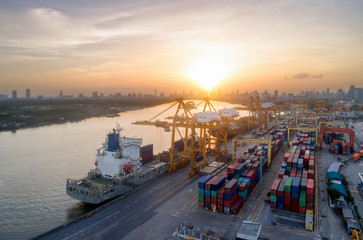 Aerial view of business port with shore crane loading container in container ship in import/export...