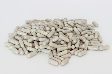Treatment, medicine, vitamins, antibiotics, weight loss, sleeplessness – a many gray capsules on the white background