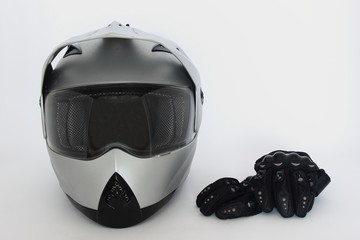 Motocross, Enduro – gray helmet with closed visor and black Moto gloves on white background, side view