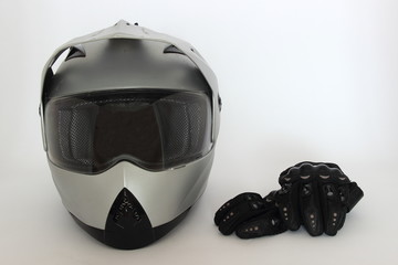 Motocross, Enduro – gray helmet with closed visor and black Moto gloves on white background, side...