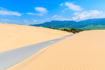 Fototapeta na wymiar Road and sand dunes near Paloma beach, Costa de la Luz, Spain