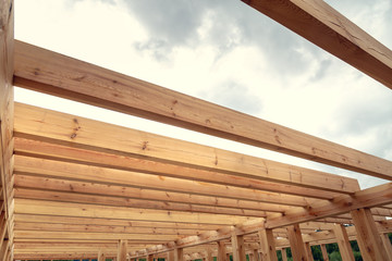 Wooden construction of an unfinished house. Skeleton of a building made of beams.