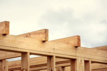 Wooden construction of an unfinished house. Skeleton of a building made of beams.