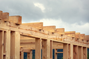 Wooden construction of an unfinished house. Skeleton of a building made of beams.