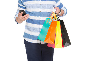 Smartphone and shopping bags in hands of buyer. Online shopping with telephone. Uptoday mobile commerce. E-commerce discounts sales
