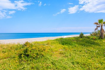 View of beautiful beach with tropical plants in small coastal village near Marbella on Costa de Sol, Spain