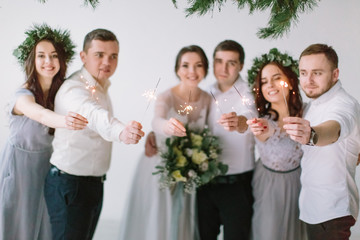 Wedding couple bride and groom and their friends standing with Bengal fires and having fun