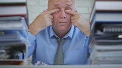 Businessman In Office Room Rubbing His Tired Eyes With Hands