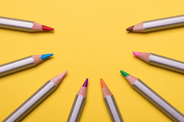 Set of colored pencils for drawing on a yellow background.