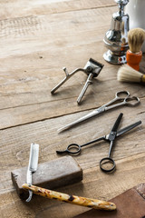 Obraz na płótnie Canvas Old vintage barbershop tools on wooden table - barbershop background with copy-space