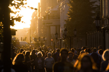 Obraz na płótnie Canvas Silhouette crowd of people walking down the pedestrian zone at summer evening sunset