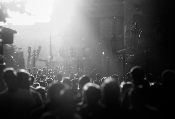 Black and white silhouette of people crowd walking down the pedestrian street under the sunshine