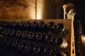 Pupitre and bottles inside an underground cellar for the production of traditional method sparkling wines in italy - 210475233