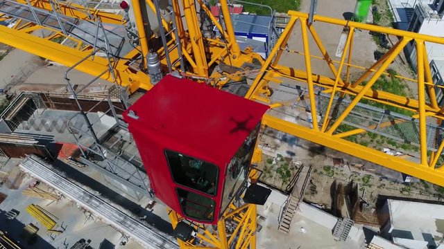 Aerial close up footage tower crane operating cabin also showing drone shadow on most tower cranes the operating cabin sits above slewing unit it contains the operating controls LMI scale anemometer