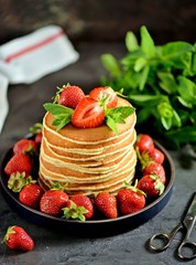Delicious pancakes with fresh organic strawberries and mint