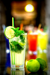 Glasses of cocktails on bar background