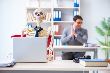 Businessman working with skeleton in office