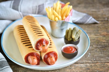 French hot dog with ketchup, mustard, mayonnaise and marinated cucumber.