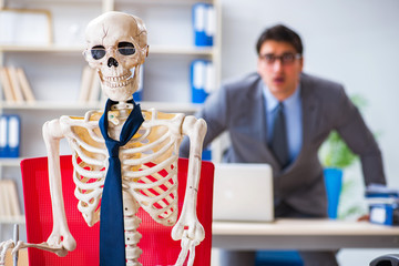 Businessman working with skeleton in office