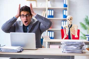 Businessman working with skeleton in office