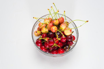 Cherries. Cherry. Cherries in color bowl and kitchen napkin. Red cherry. Fresh cherries. Cherry on white background.