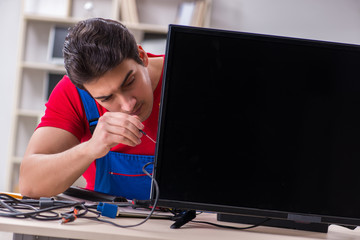 Professional repair engineer repairing broken tv