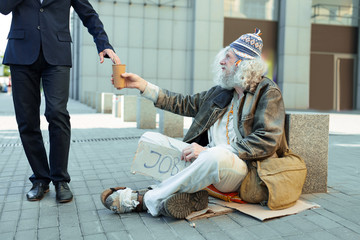 Street person. Poor helpless street person feeling lost while sitting on the street begging for...